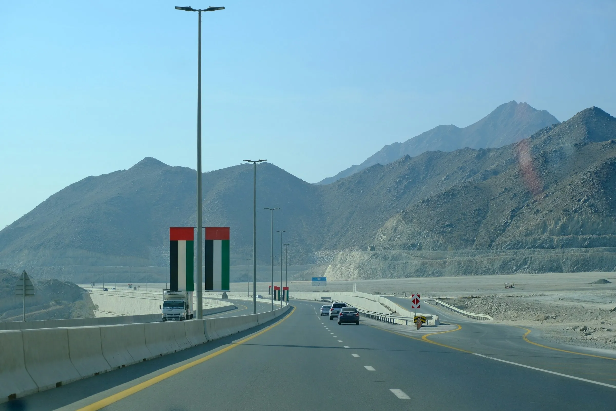 A truck and several cars drive along a mountain highway near Khor Fakkan in the UAE.
