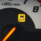 Instrument cluster with an amber traction-control warning light lit up beside the rev counter.